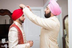 SIkh indian groom getting help with his bridal attire. SIkh indian groom getting help with his bridal attire.