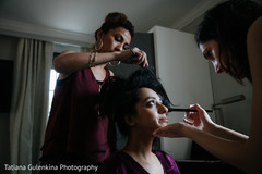 Indian bride being dolled up by a makeup artist and hairstylist. Indian bride being dolled up by a makeup artist and hairstylist.