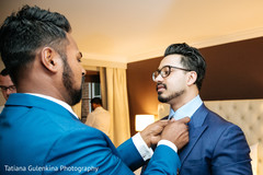 Groomsmen being help with suit. Groomsmen being help with suit.