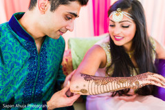 Groom admiring the bride's mehndi. Groom admiring the bride's mehndi.