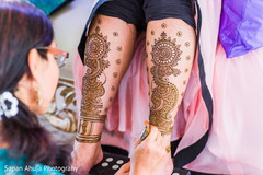 Mehndi artist giving the final touches to the bridal mehndi design. Mehndi artist giving the final touches to the bridal mehndi design.