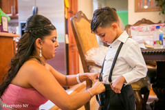 Indian bridesmaid helping kid to get ready for wedding ceremony Indian bridesmaid helping kid to get ready for wedding ceremony