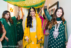 Pakistani bride in yellow mehndi dress and flower jewelry. indian pre-wedding celebrations,indian wedding guests,pakistani bride