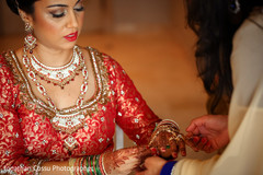 Indian bride getting some help with her jewelry. indian bride getting ready,indian bride,indian bridal jewelry